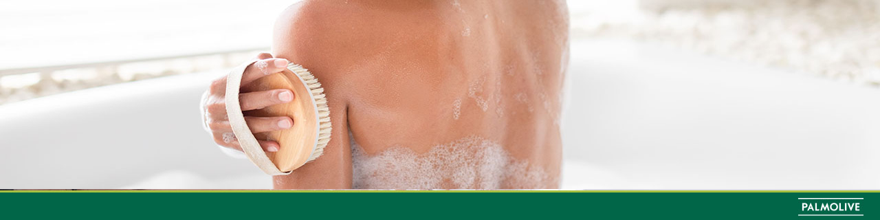 Mulher de costas em uma banheira tomando banho com um sabonete perfumado 
